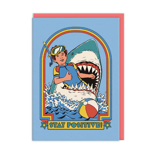 Illustration of a person holding a thumbs up whilst hanging out of  a shark's mouth with 'Stay Positive!' text on a blue background