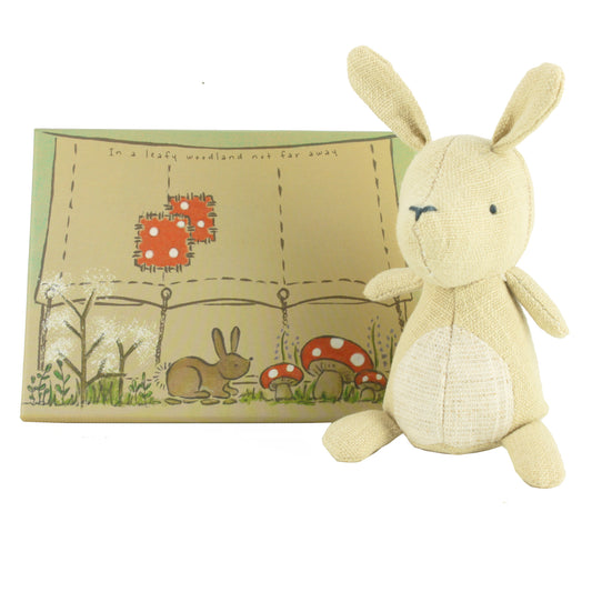Plush rabbit toy with cream coloured pouch featuring a card box with a woodland scene on a white background
