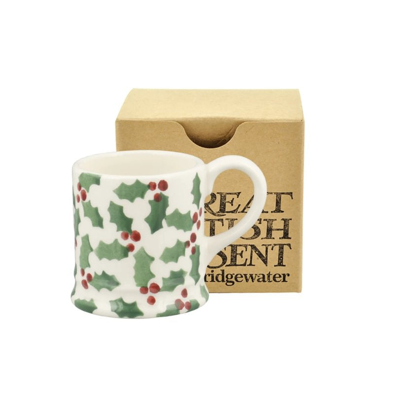 Mug with holly pattern in a box labelled 'Emma Bridgewater' on a white background
