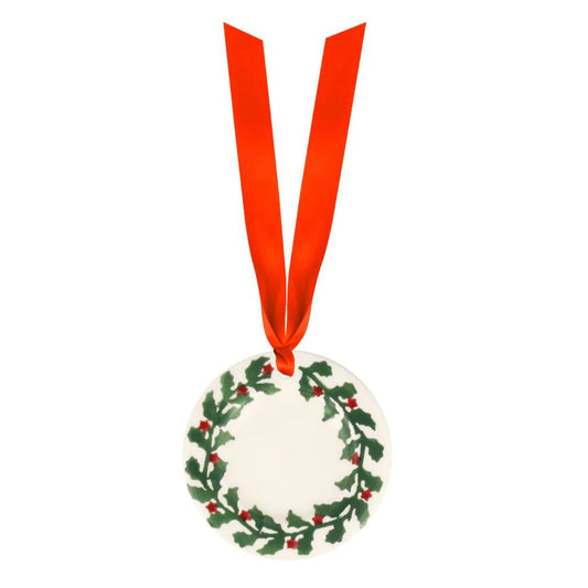 Round Christmas ornament with holly design and red ribbon on a white background