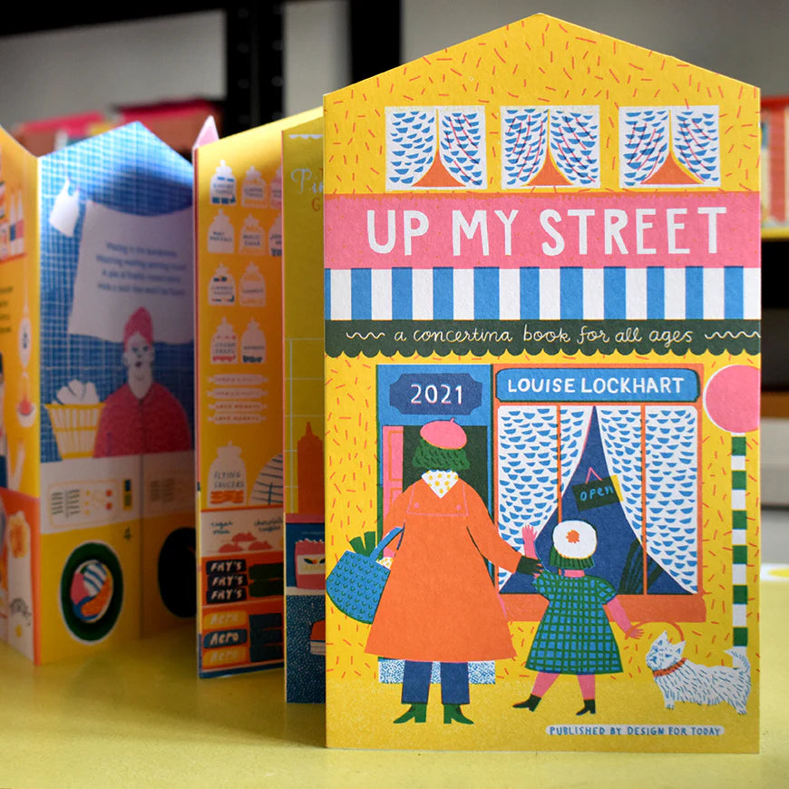 Colorful book titled 'Up My Street' by Louise Lockhart with a house-shaped cover.