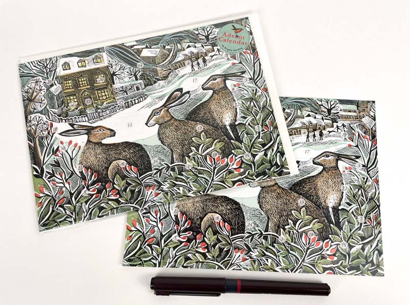 An illustrated advent card depicting three hares in a wintry landscape with holly and berries.