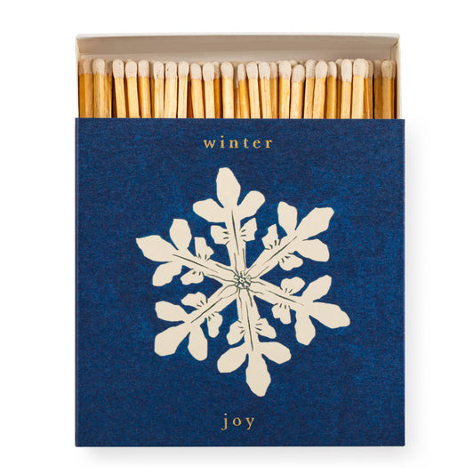 Matchbox with snowflake design and 'winter joy' text on a white background