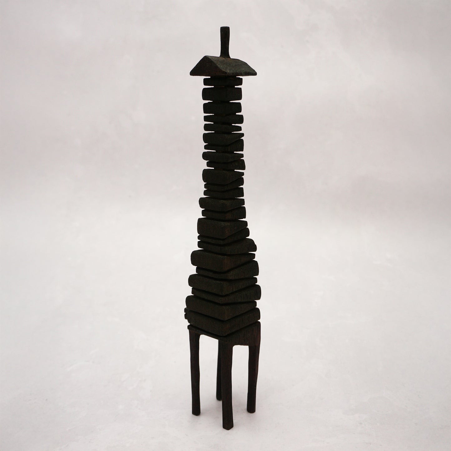 Black wooden house sculpture on a white background
