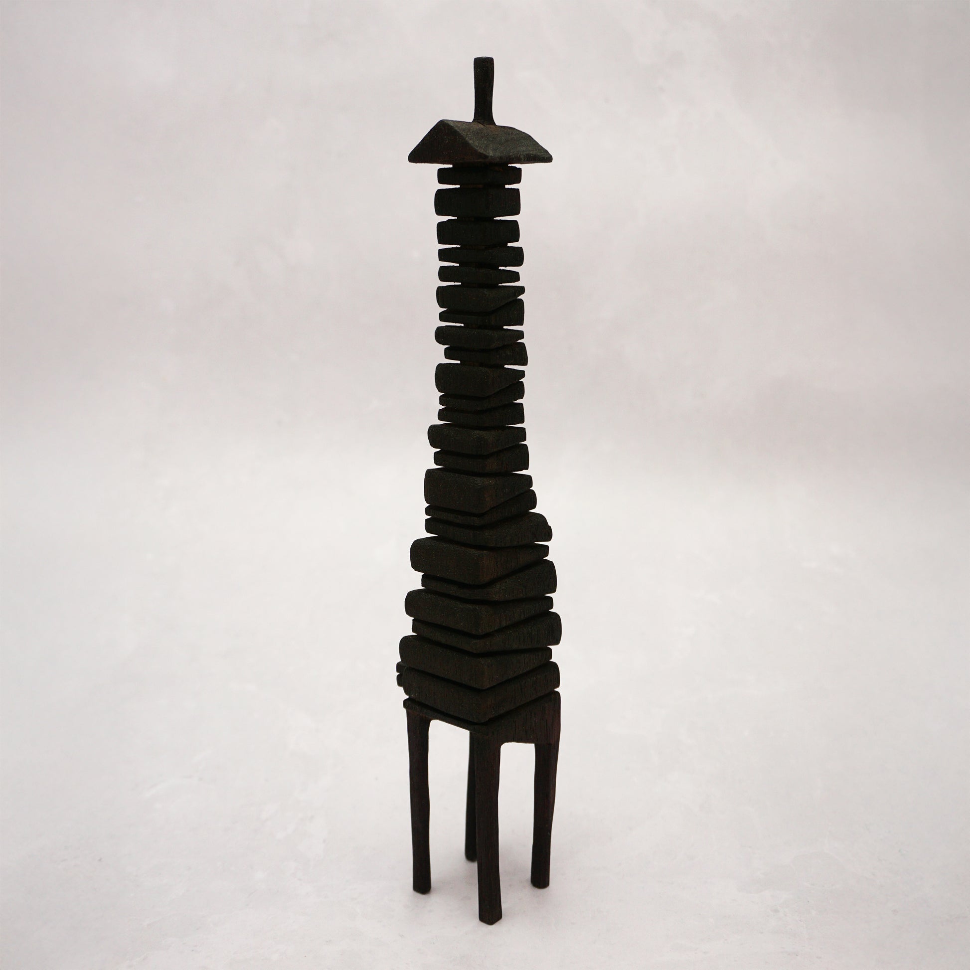 Black wooden house sculpture on a white background