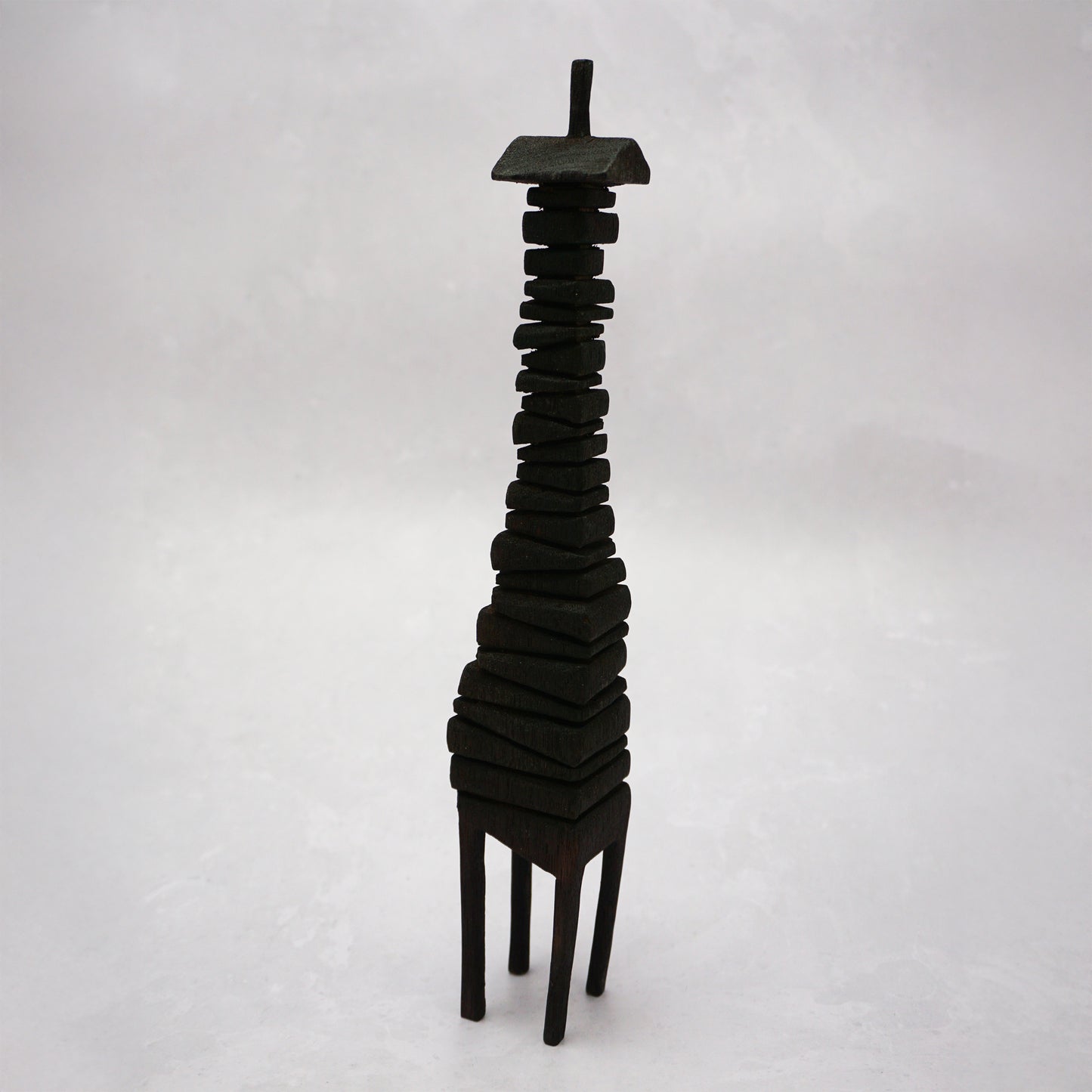 Black wooden house sculpture on a white background