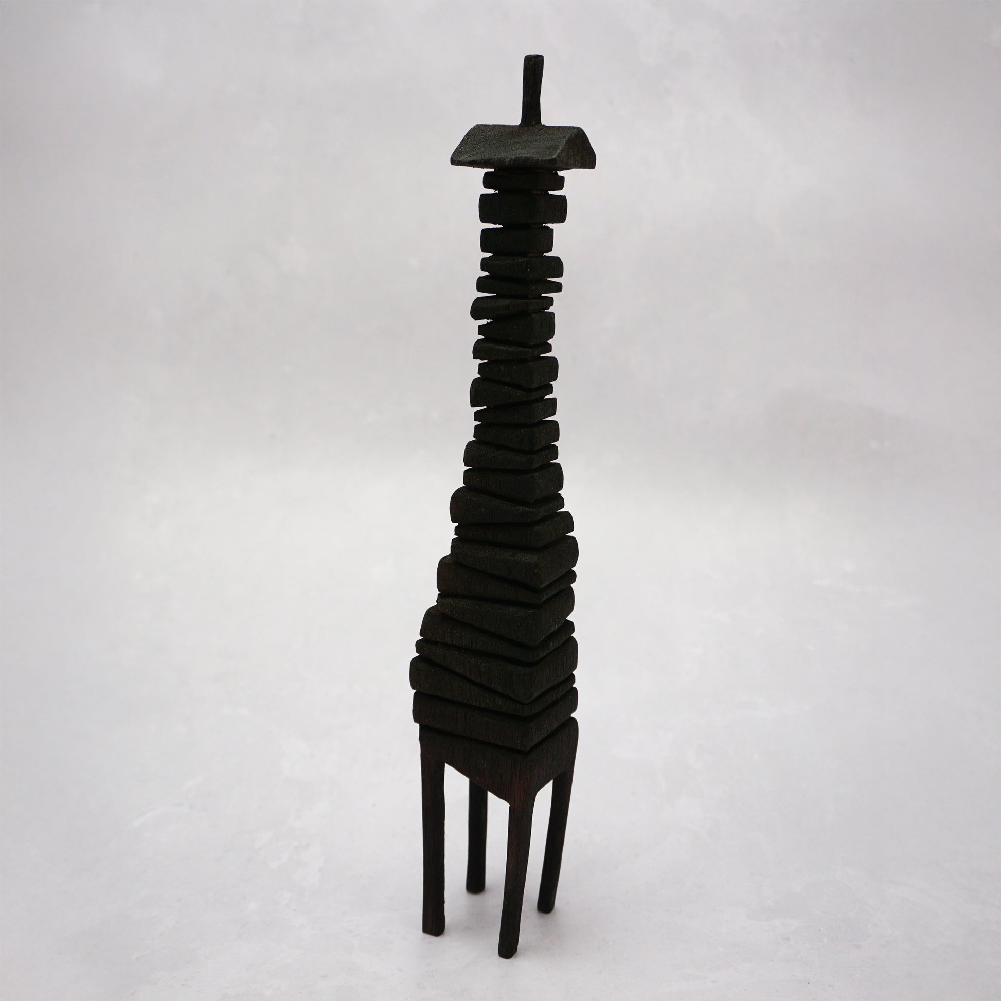 Black wooden house sculpture on a white background