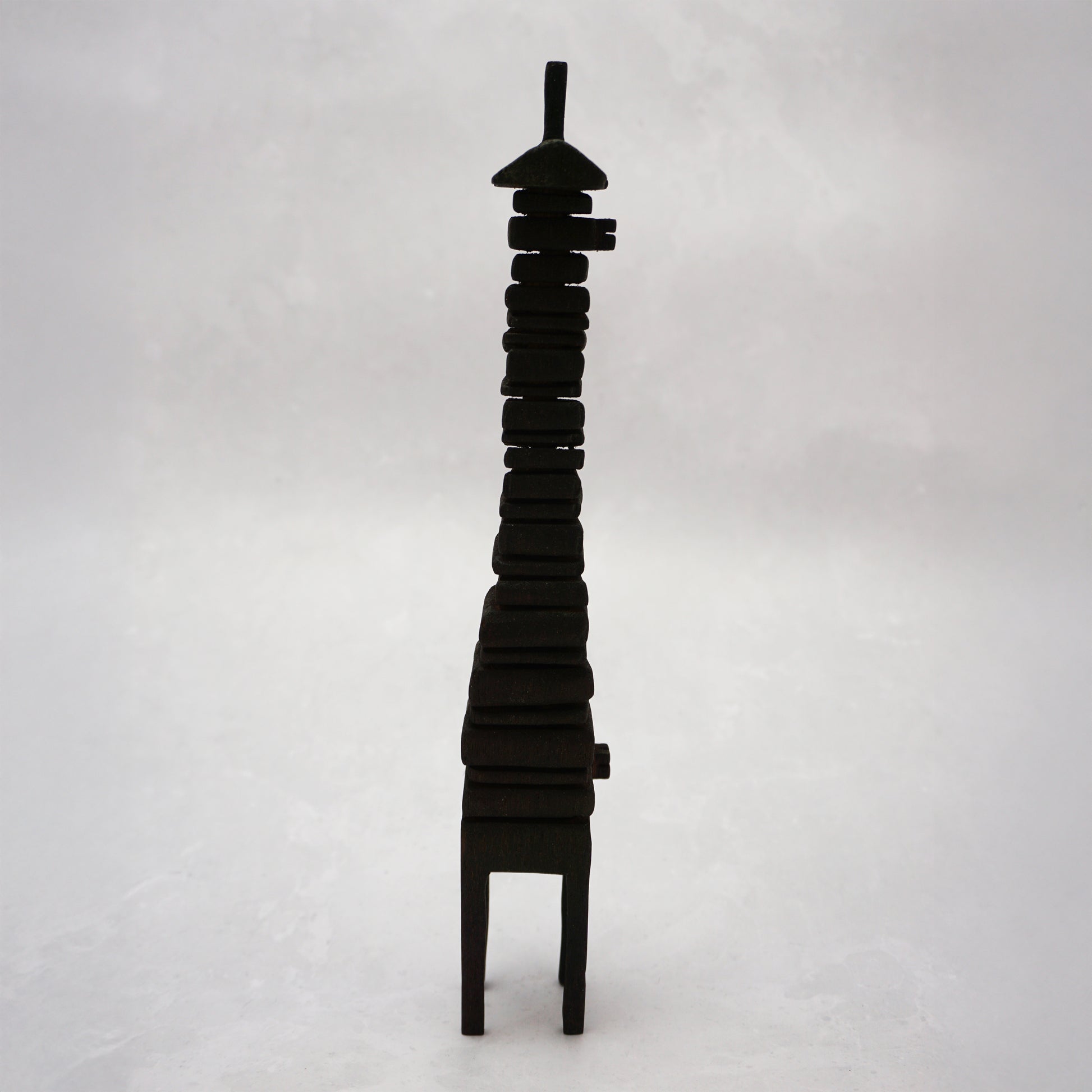 Black wooden house sculpture on a white background