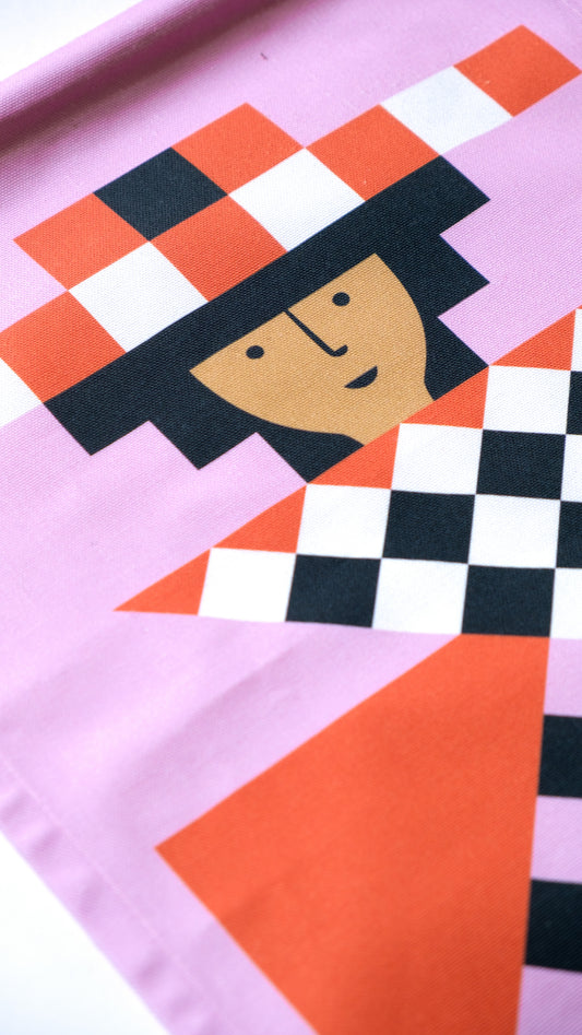 A detailed close up of a fabric banner featuring a pink and red geometric figure with black and white accents. 