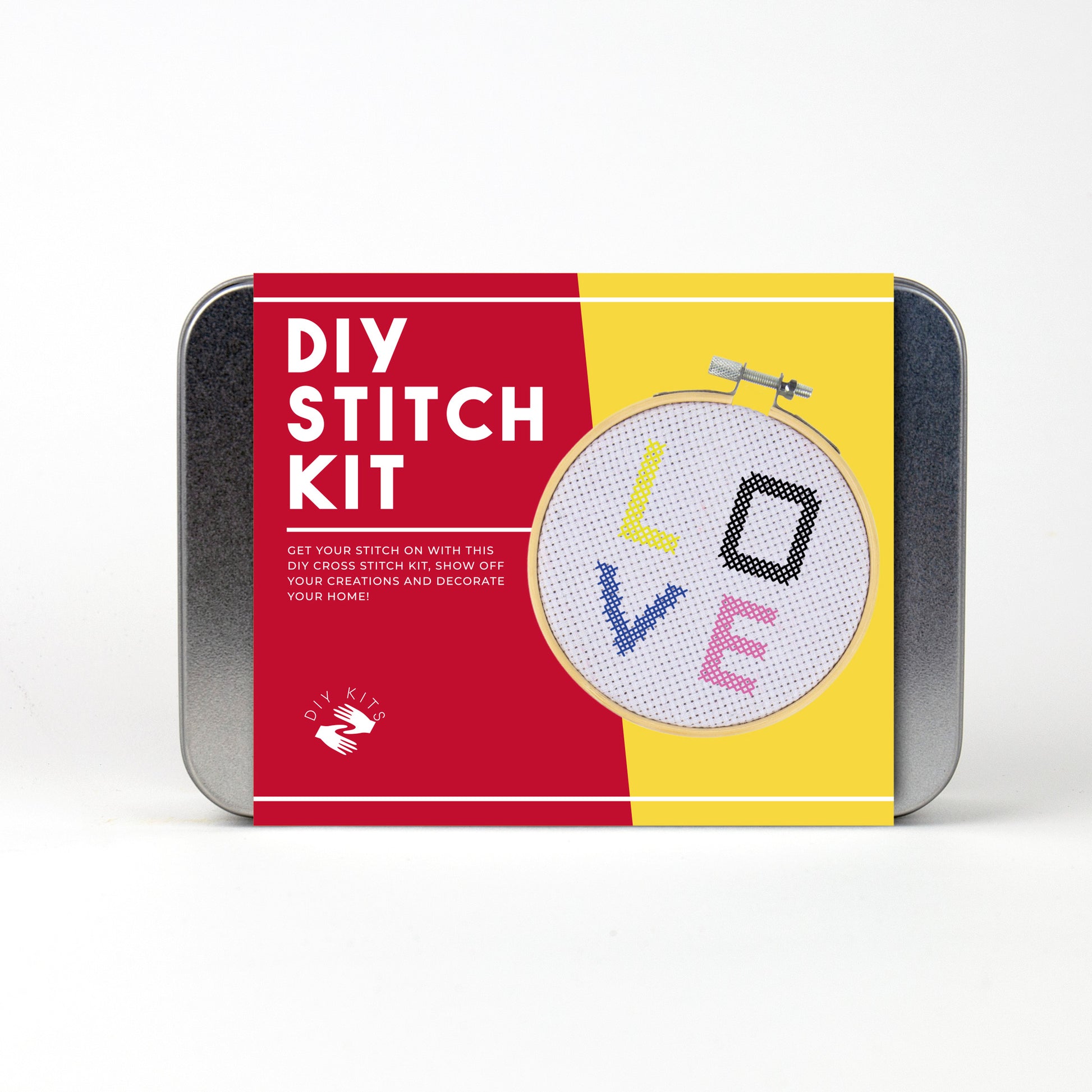 A metal tin DIY stitch kit with red and yellow branding and a picture of cross stitch on a hoop.