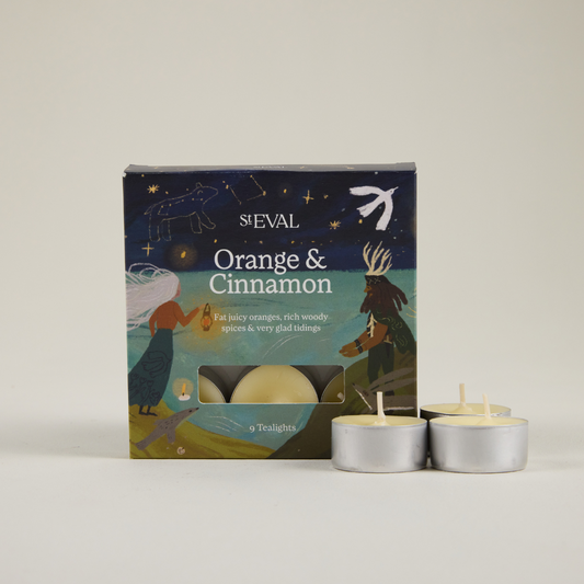 St Eval Orange & Cinnamon tealight candles with packaging on a neutral background.