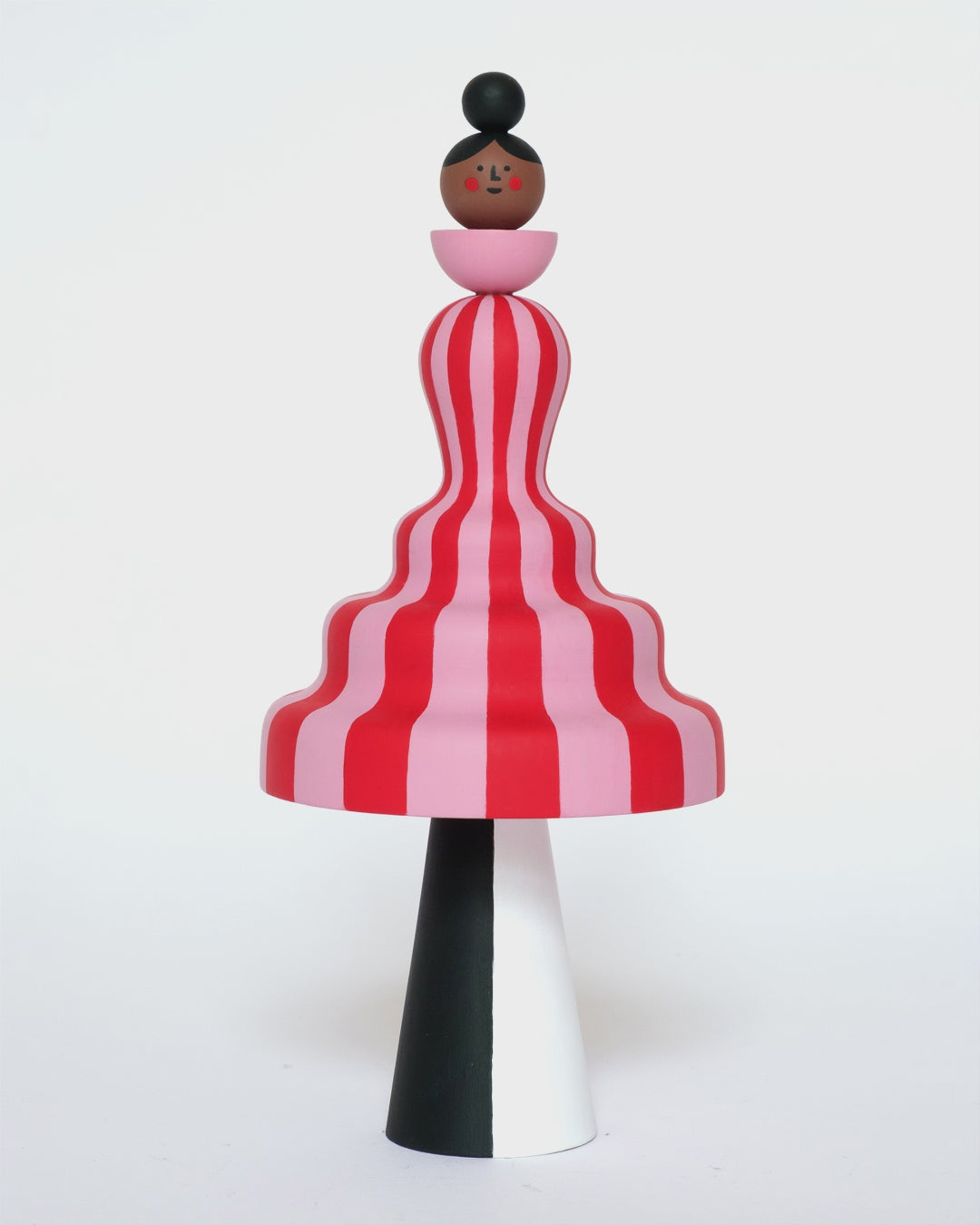 A video of a colourful sculpture with a pink and red stripey body with white and black legs on a plain white background.