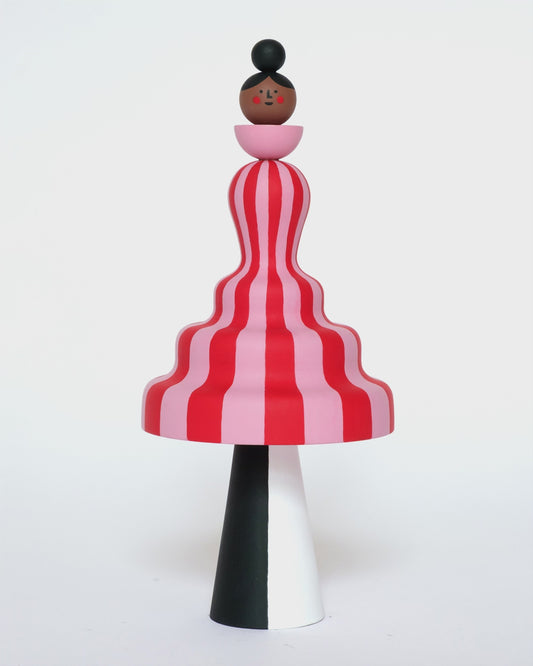 A video of a colourful sculpture with a pink and red stripey body with white and black legs on a plain white background.