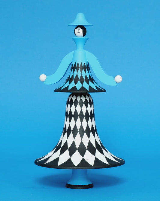 A spinning video of a colourful sculpture with a white, black and blue diamond patterned curved body with blue legs and a blue top hat on a plain blue background.