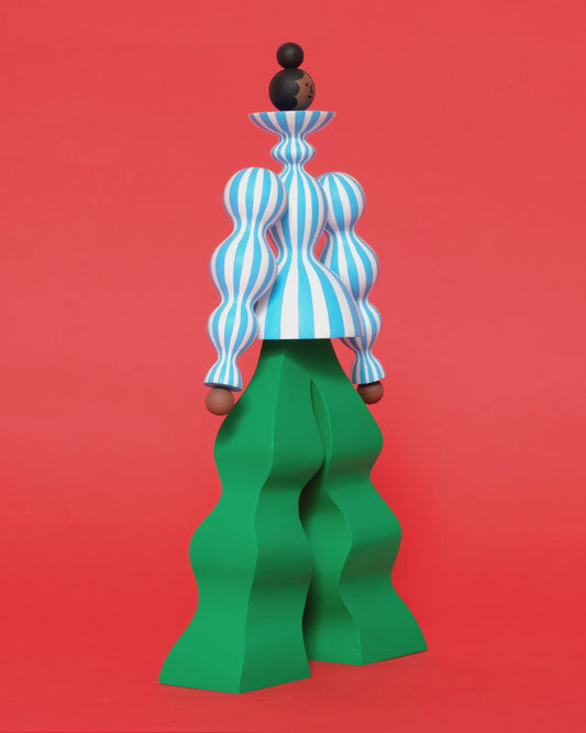 A video of a colourful sculpture with a blue and white stripey body with wavy green trousers on a plain orange background.
