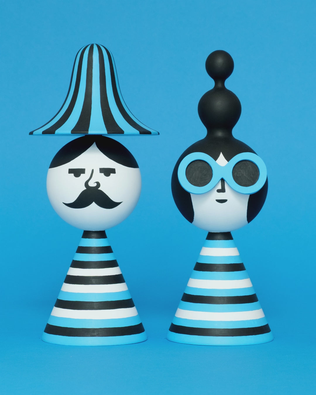 A spinning video of a pair of blue, white, and black stripey bust figures with a stripey hat and blue sunglasses on a plain blue background.