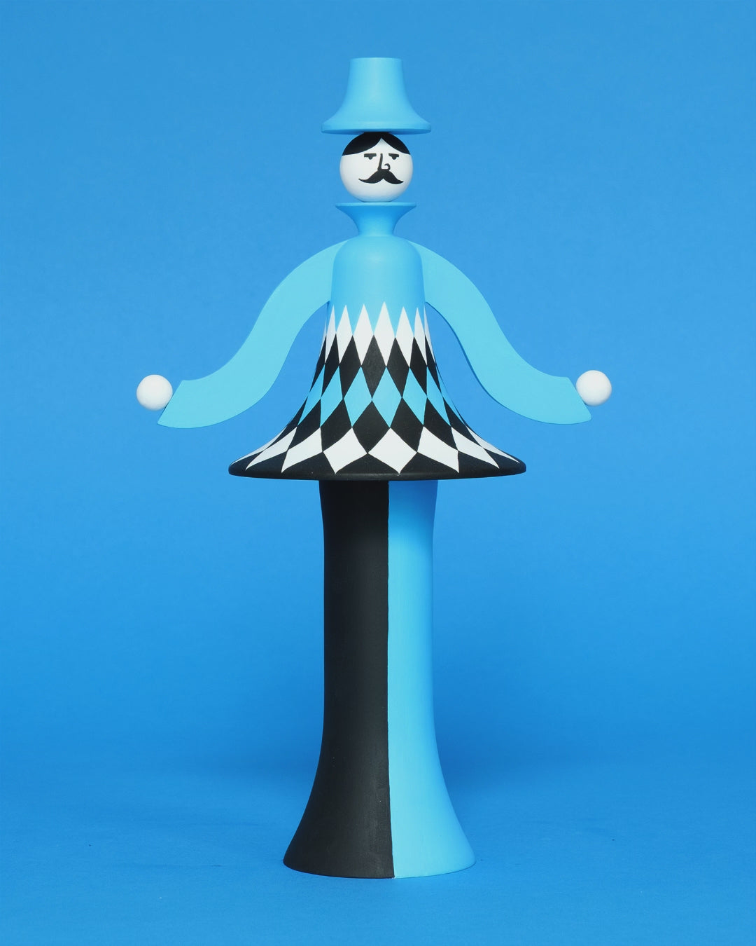 A spinning video of a colourful sculpture with a white, black and blue diamond patterned curved body with blue and black legs and a blue top hat on a plain blue background.