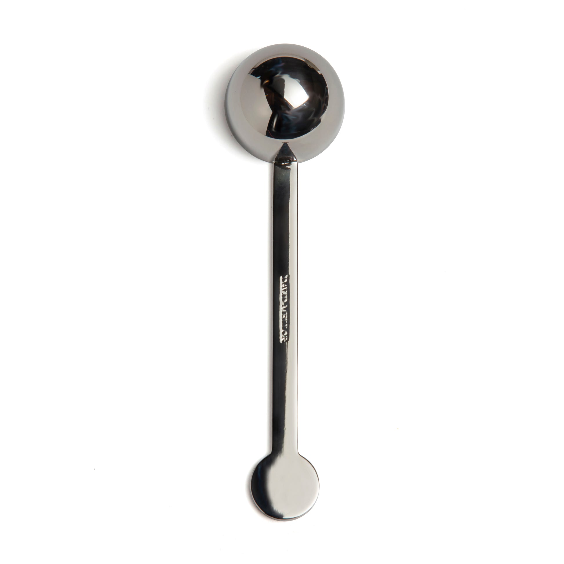 A stainless steel measuring spoon with a round bowl and a long handle, positioned vertically against a plain white background. The spoon has a polished finish, reflecting light subtly.