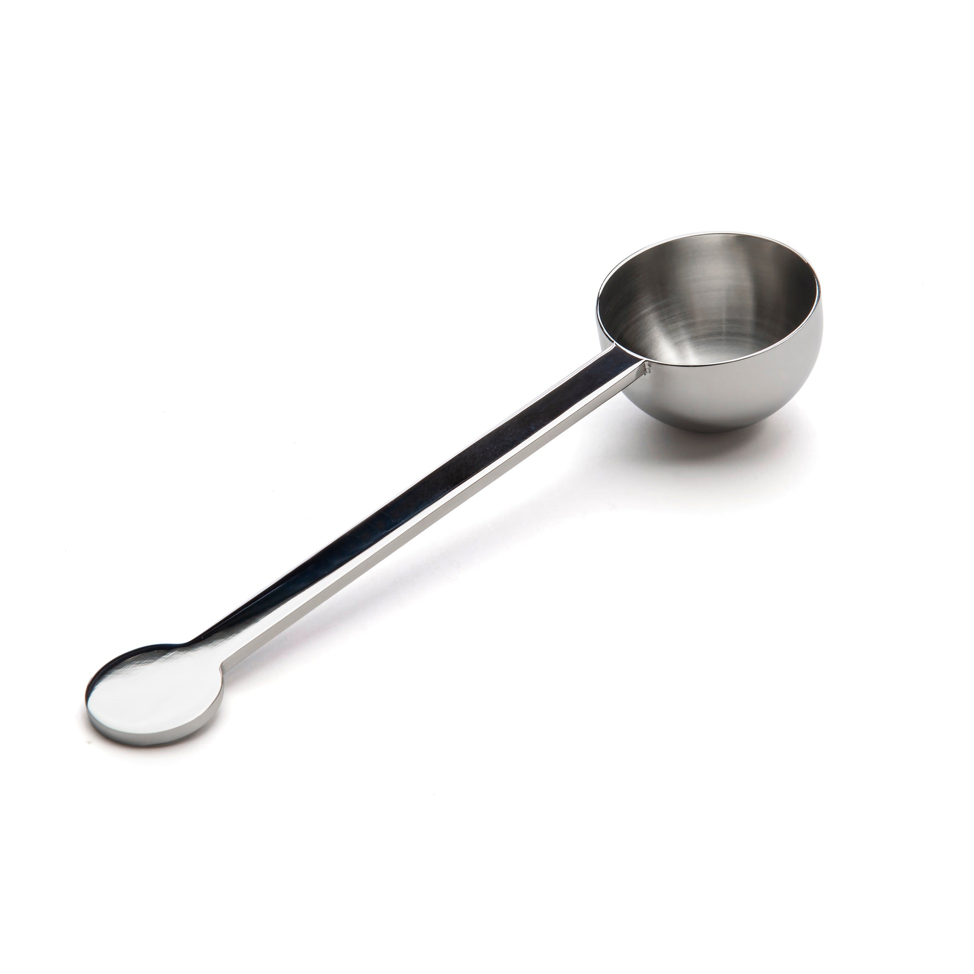A stainless steel measuring spoon with a round bowl and a long handle, positioned vertically against a plain white background. The spoon has a polished finish, reflecting light subtly.