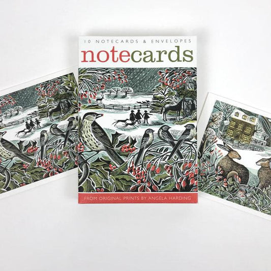 A pack of Christmas notecards featuring two original prints by Angela Harding. The prints feature wintry scenes with rabbits and birds. 