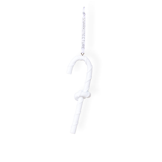 A white, twisted candy cane ornament hangs from a ribbon. The design is minimalist, featuring a smooth, curved shape with a knot in the middle. The ribbon is labelled with the brand name "SNARKitecture.