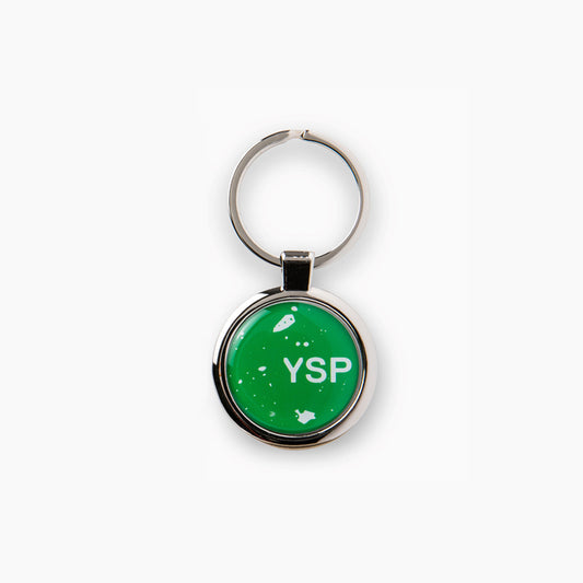 A round keyring featuring a bright green background with the letters "YSP" prominently displayed in white. 